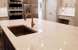 Quartz-topped kitchen island with a metallic single sink
