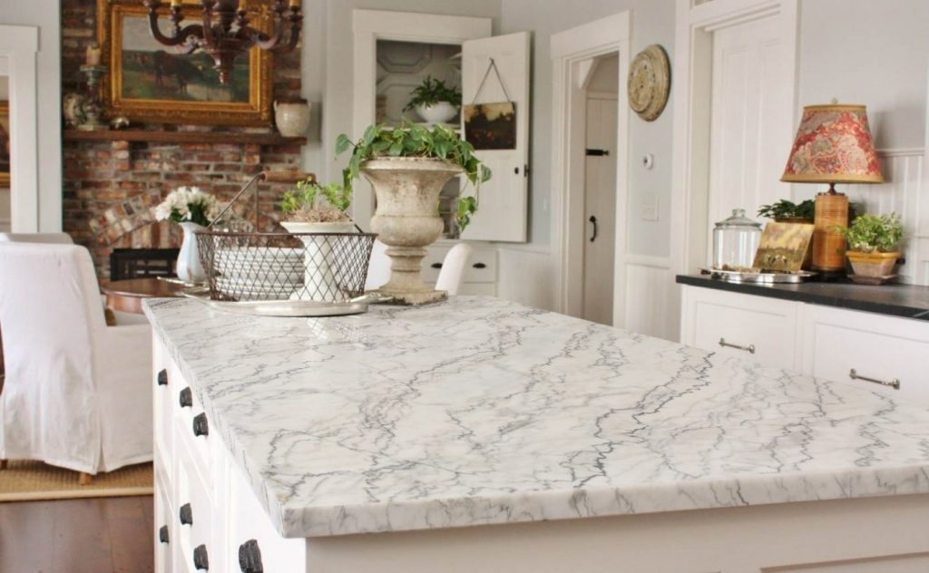 marble-topped kitchen island in a fully white living area